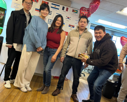 5 staff members smiling during the International Food Day lunch.