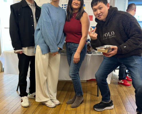 4 staff members smiling/posing during the International Food Day lunch.