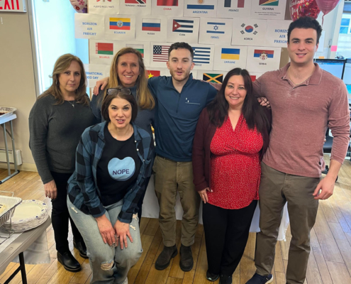 6 staff members smiling during the International Food Day lunch.