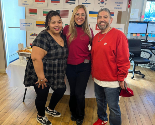 3 staff members smiling during the International Food Day lunch.