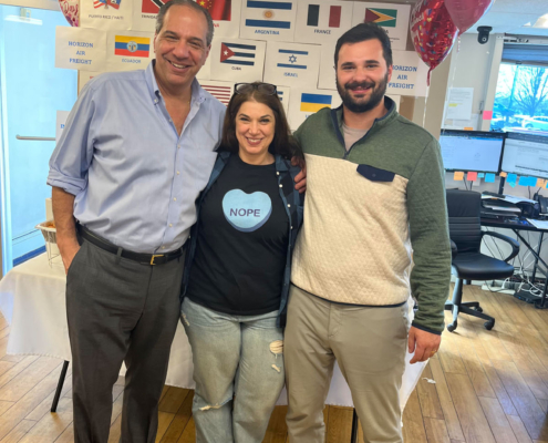 3 staff members smiling during the International Food Day lunch.